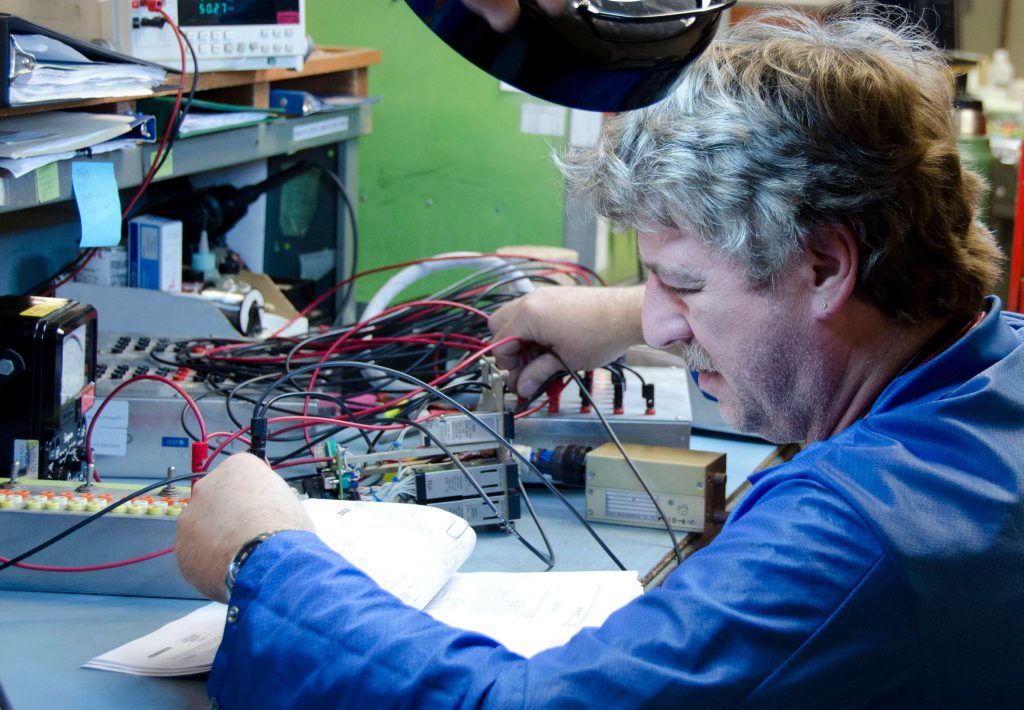 A technician setting up test equipment per technical data